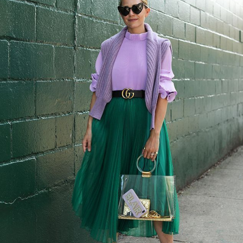 Lady wearing a green skirt and lilac purple knitted sweater