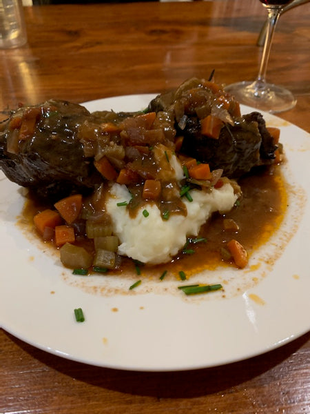 Red Wine Braised Short Ribs Served over fluffy mashed potatoes garnished with chives and enjoyed with a glass of red wine
