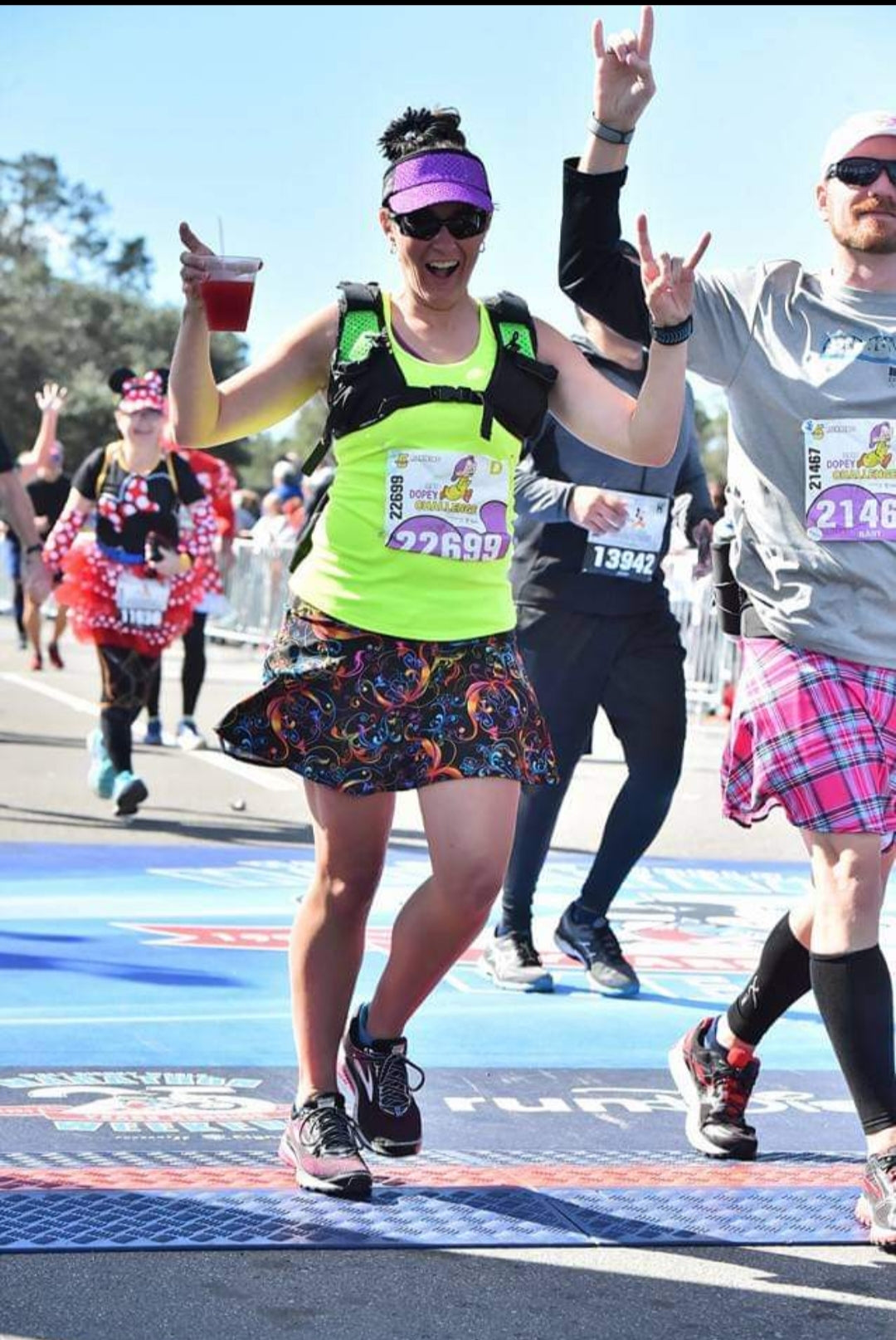 Melissa Marowelli finishing a race with drink in hand wearing a Bolder Athletic Wear skirt