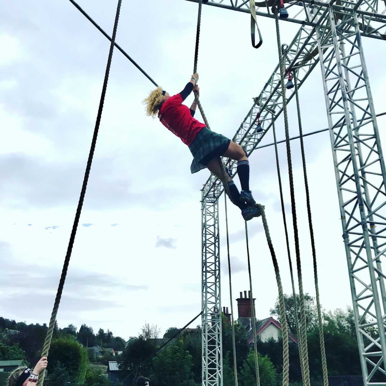 Samantha climbing a rope wearing a Bolder skirt