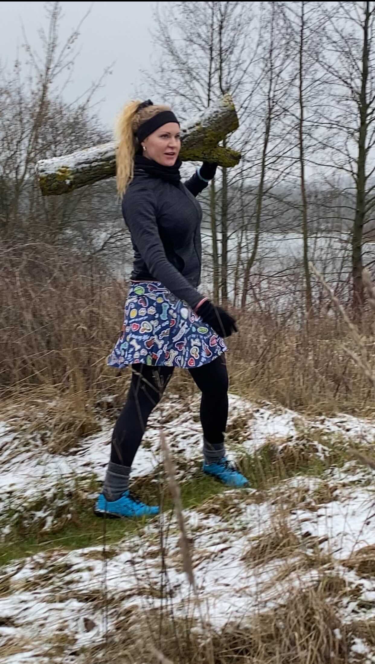 Samantha outside carrying a log wearing a Bolder skirt