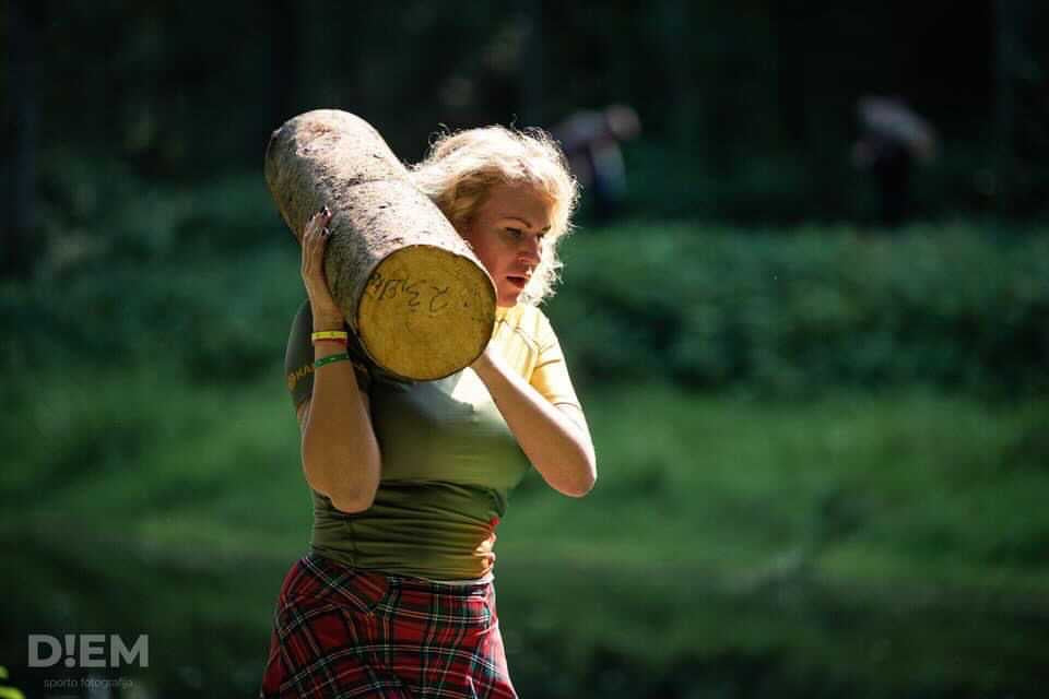 Samantha carrying a log wearing a Bolder skirt