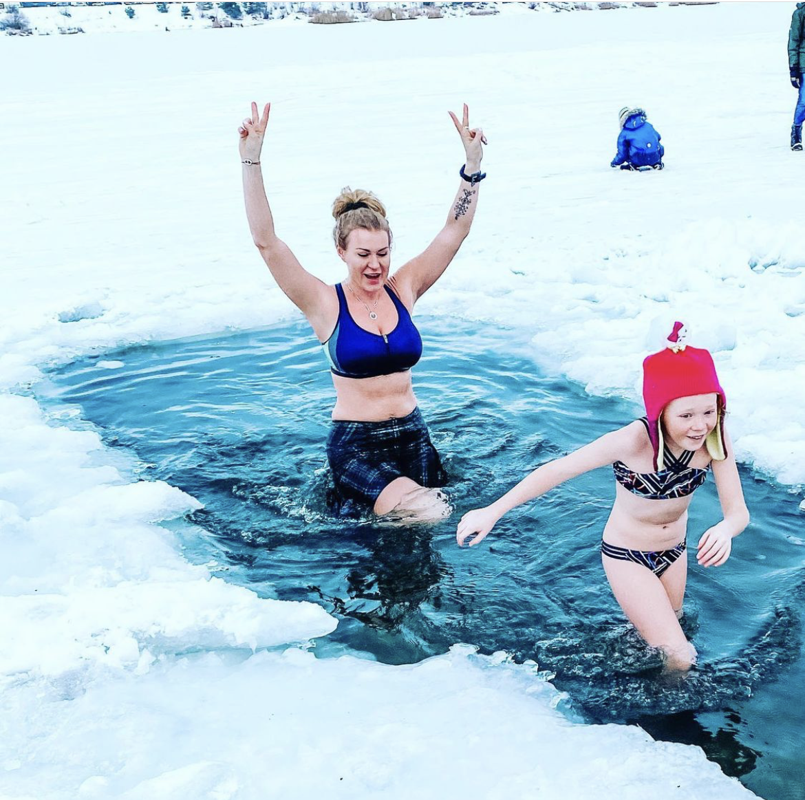Samantha wearing a Bolder skirt in an ice hole with her child
