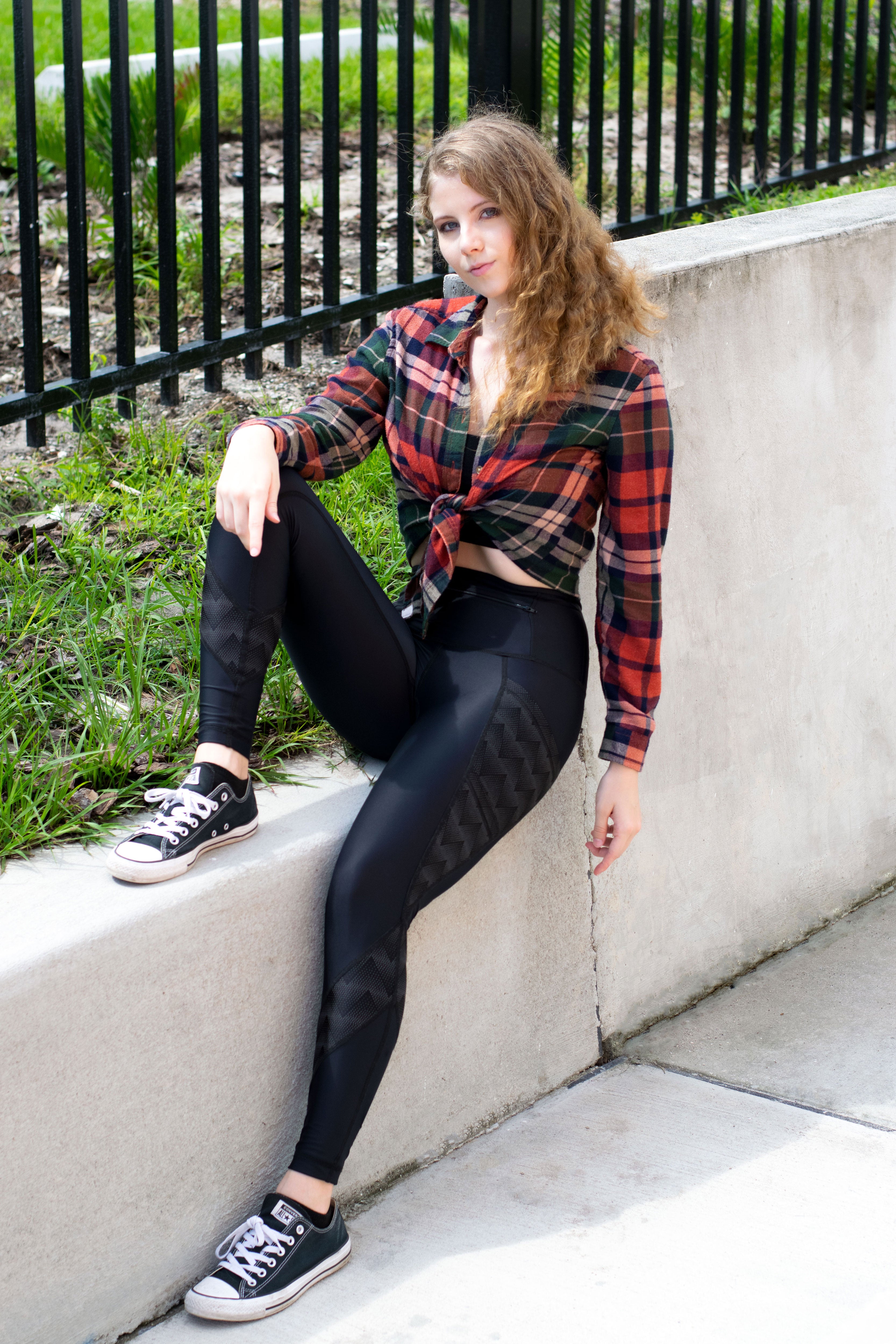 Model sitting on wall wearing Zag Reflective leggings