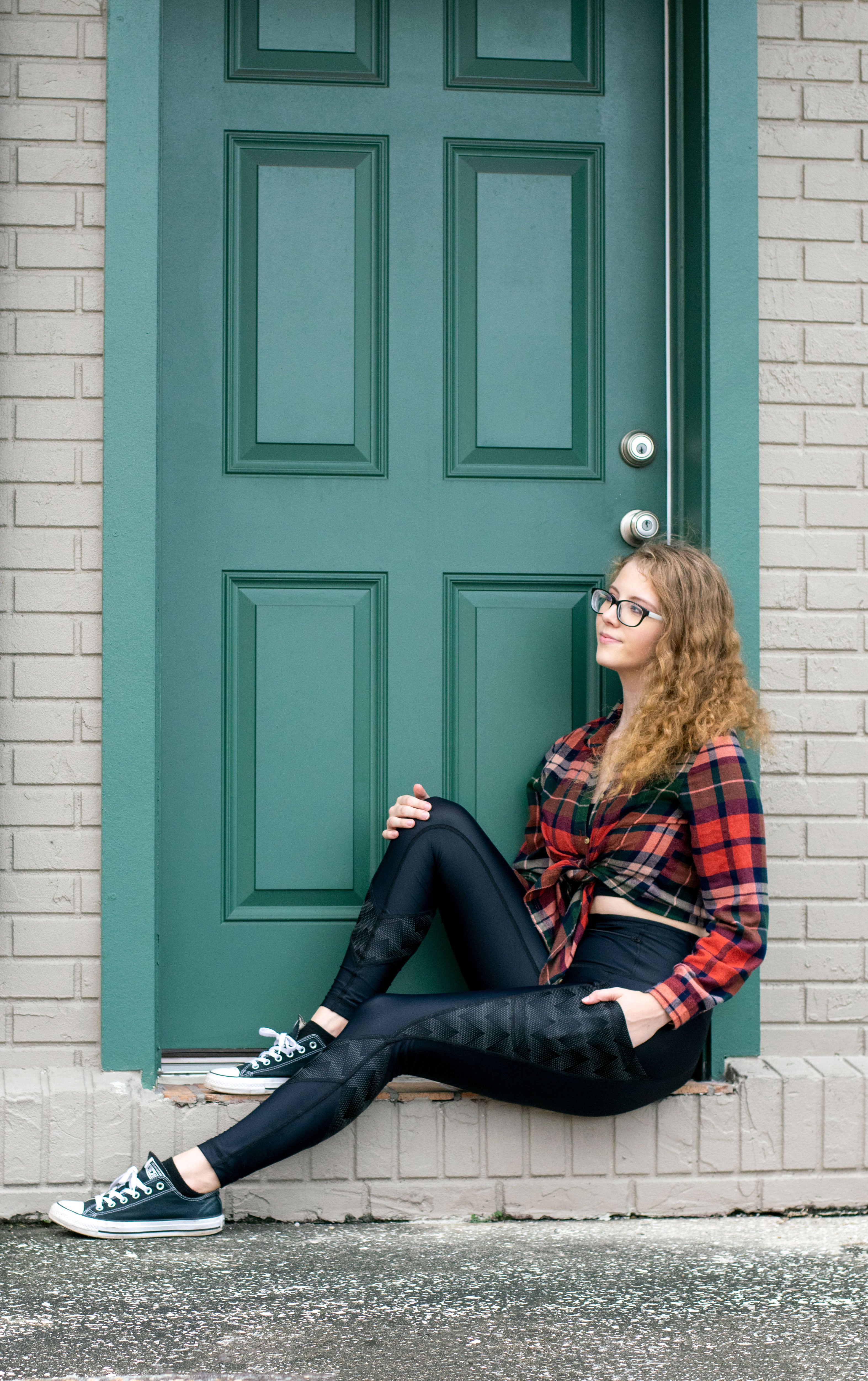 Model sitting in doorway wearing Zag Reflective leggings