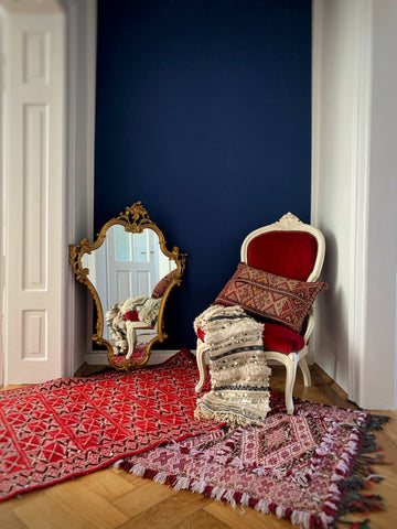 Hallway with baroque style chair and mirror. Rugs on rugs