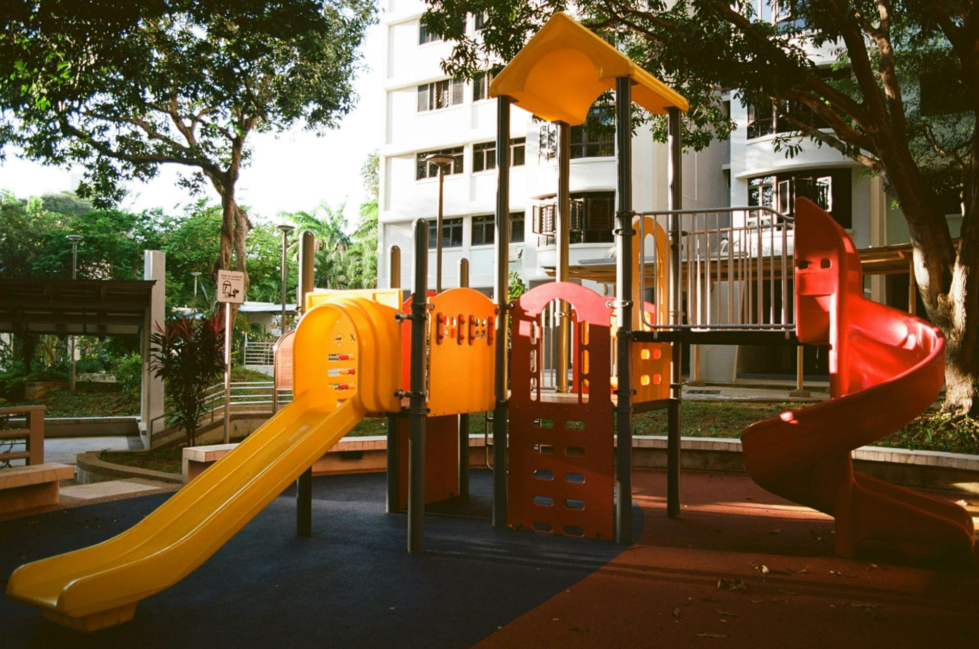 Colorful children’s playground equipment with slides and climbing structures in a park setting