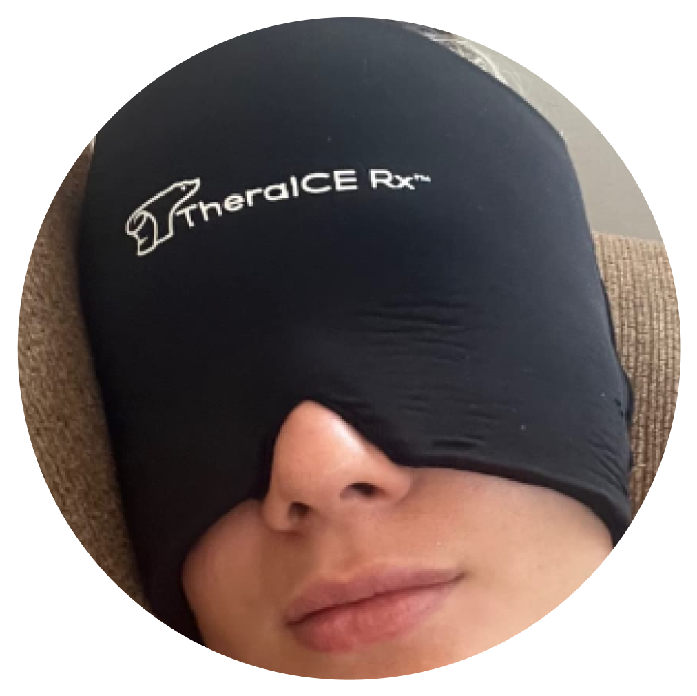 Person wearing a full-face black therapeutic mask with visible brand logo.