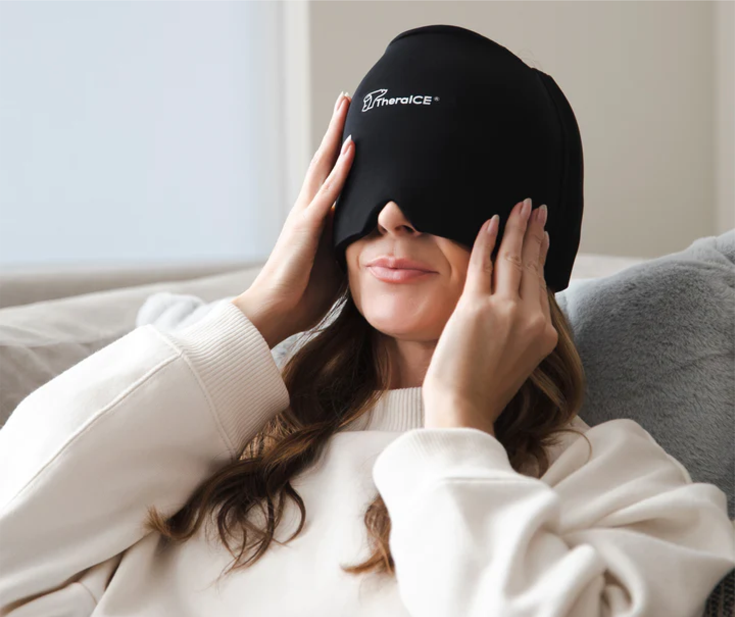 Woman wearing a therapeutic eye mask while sitting on a couch.