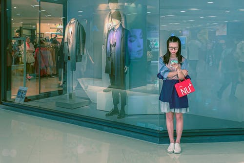 Young Woman Using Phone In A Mall