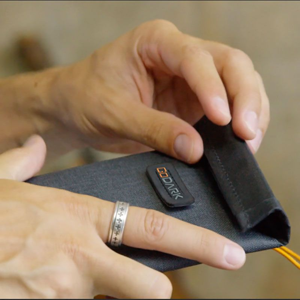 A pair of hands holding a GoDark Bag