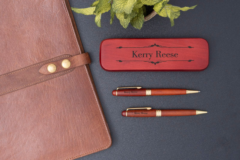 Deluxe Rosewood Pen and Pencil Set with Case next to a leather padfolio