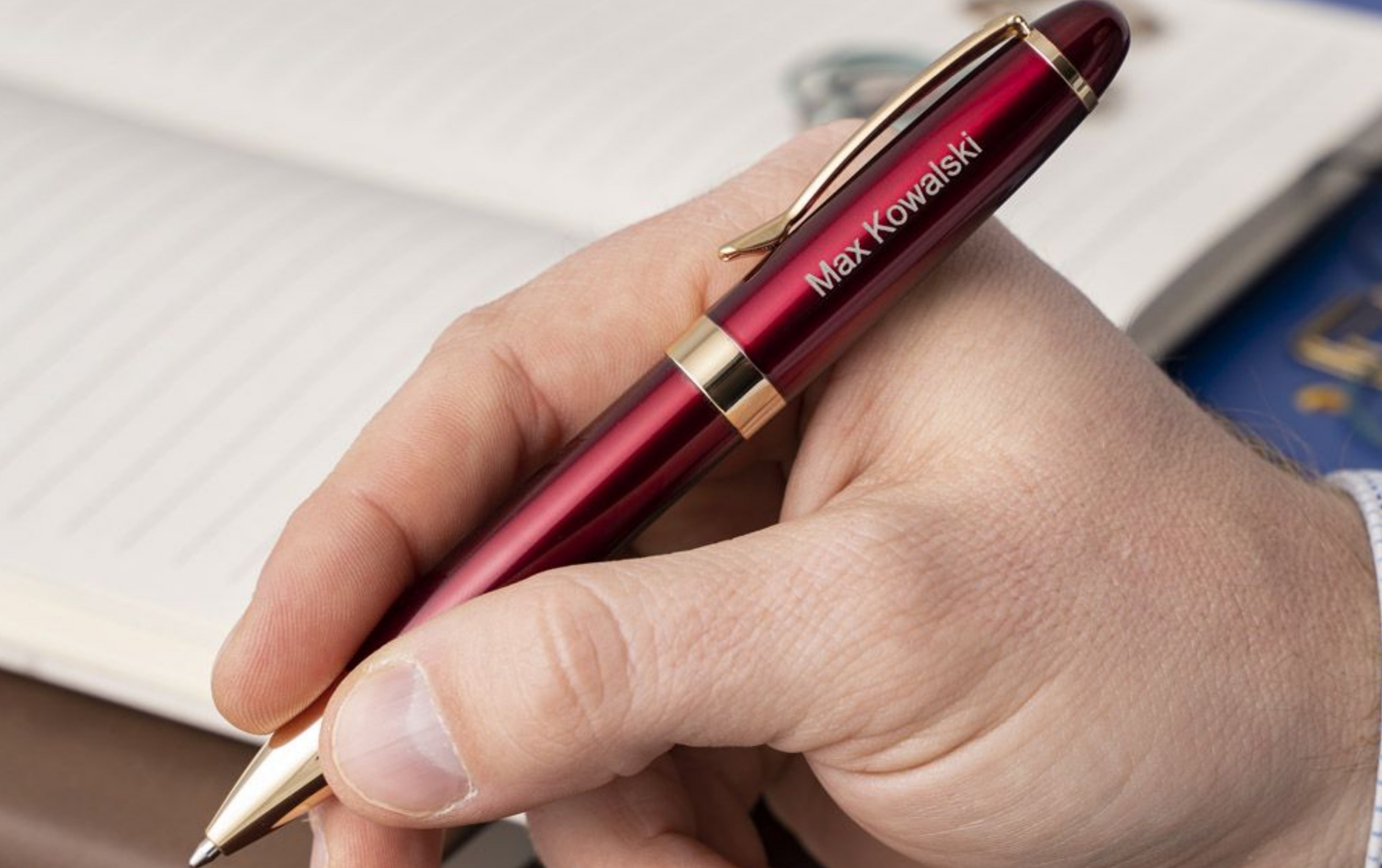 Man holding engraved Alexandria Red Ballpoint to take notes