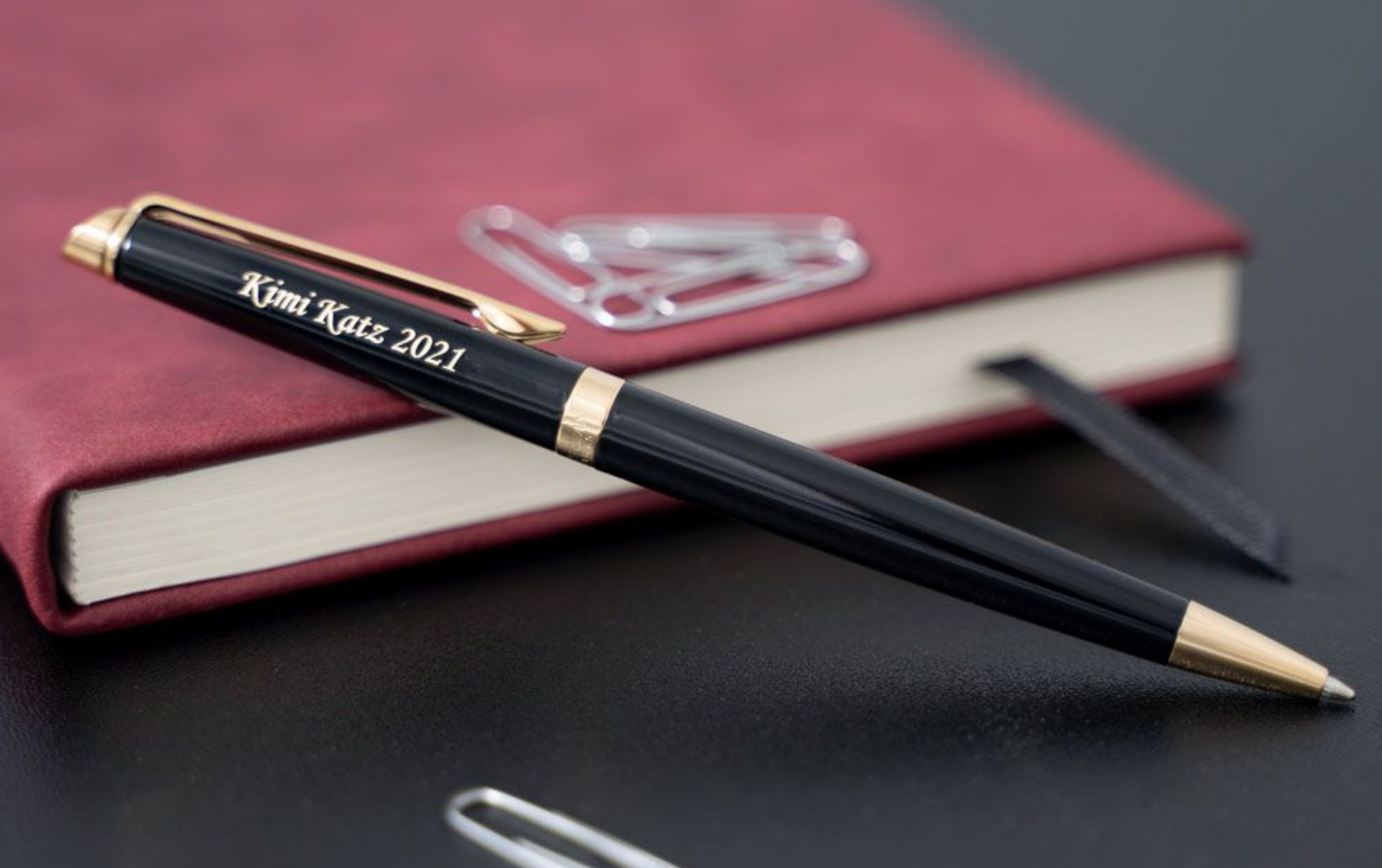 Engraved Hemisphere Black Ballpoint displayed next to journal and desk items