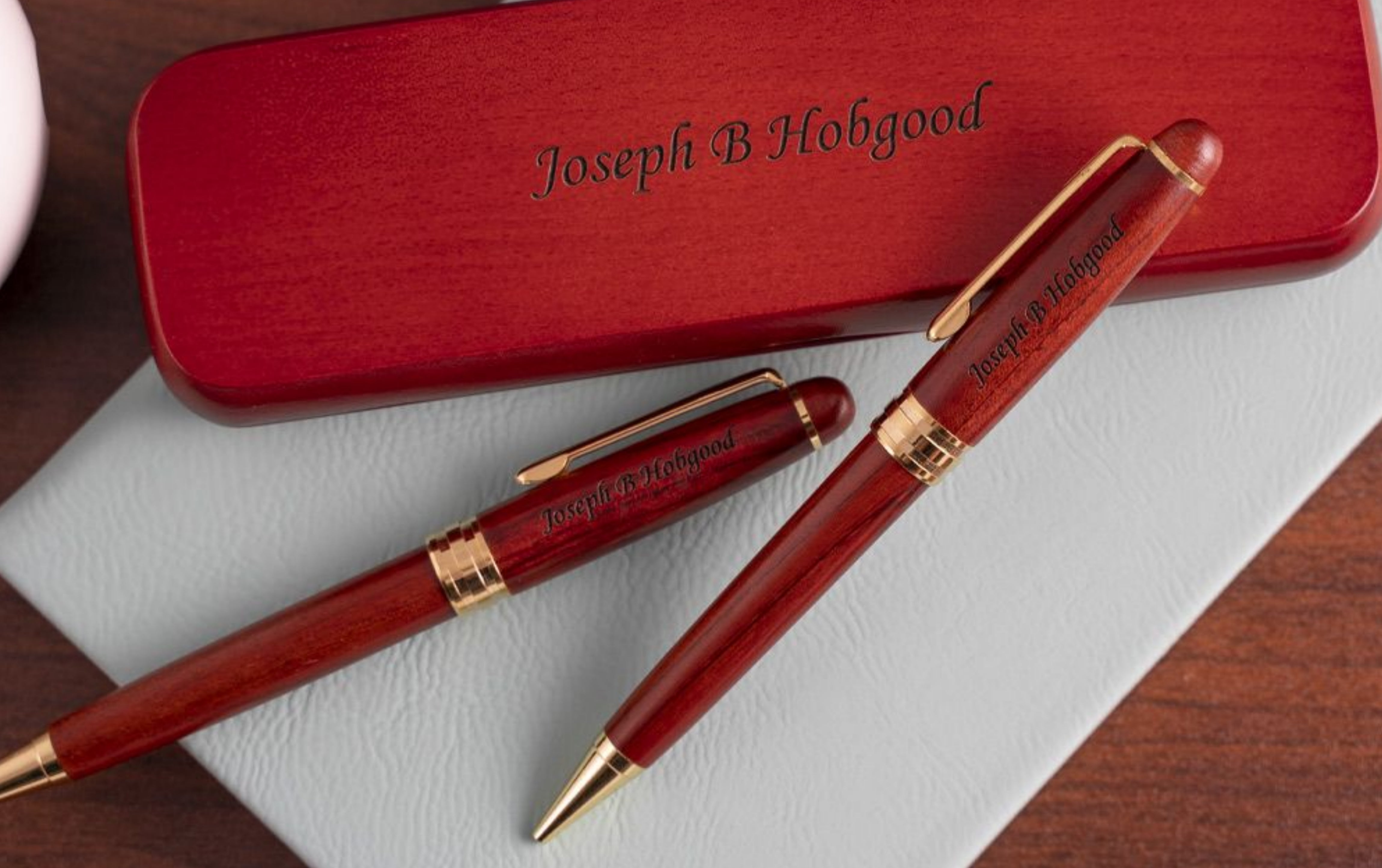 Engraved Rosewood Pen and Pencil Set next to display case