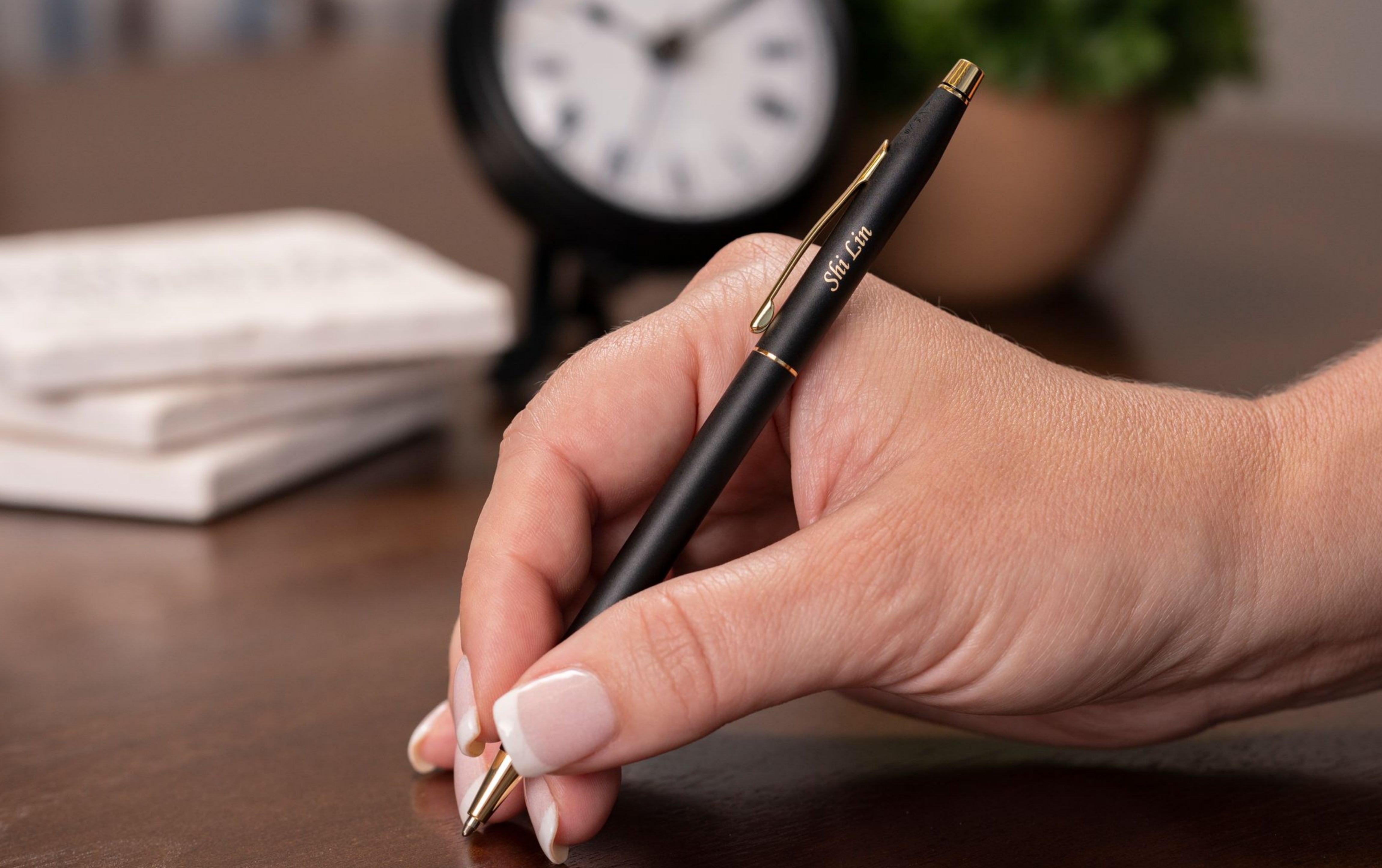 woman holding engraved black ballpoint pen