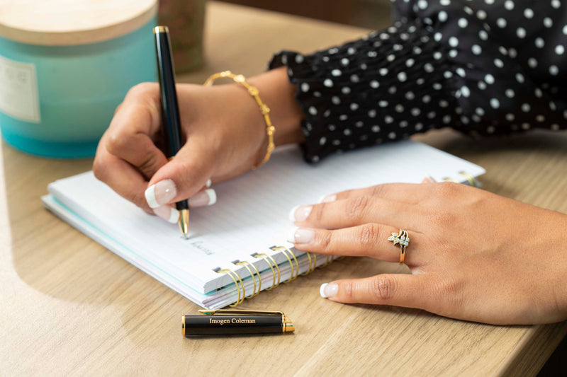 A woman writes with a Waterman Hemisphere rollerball pen