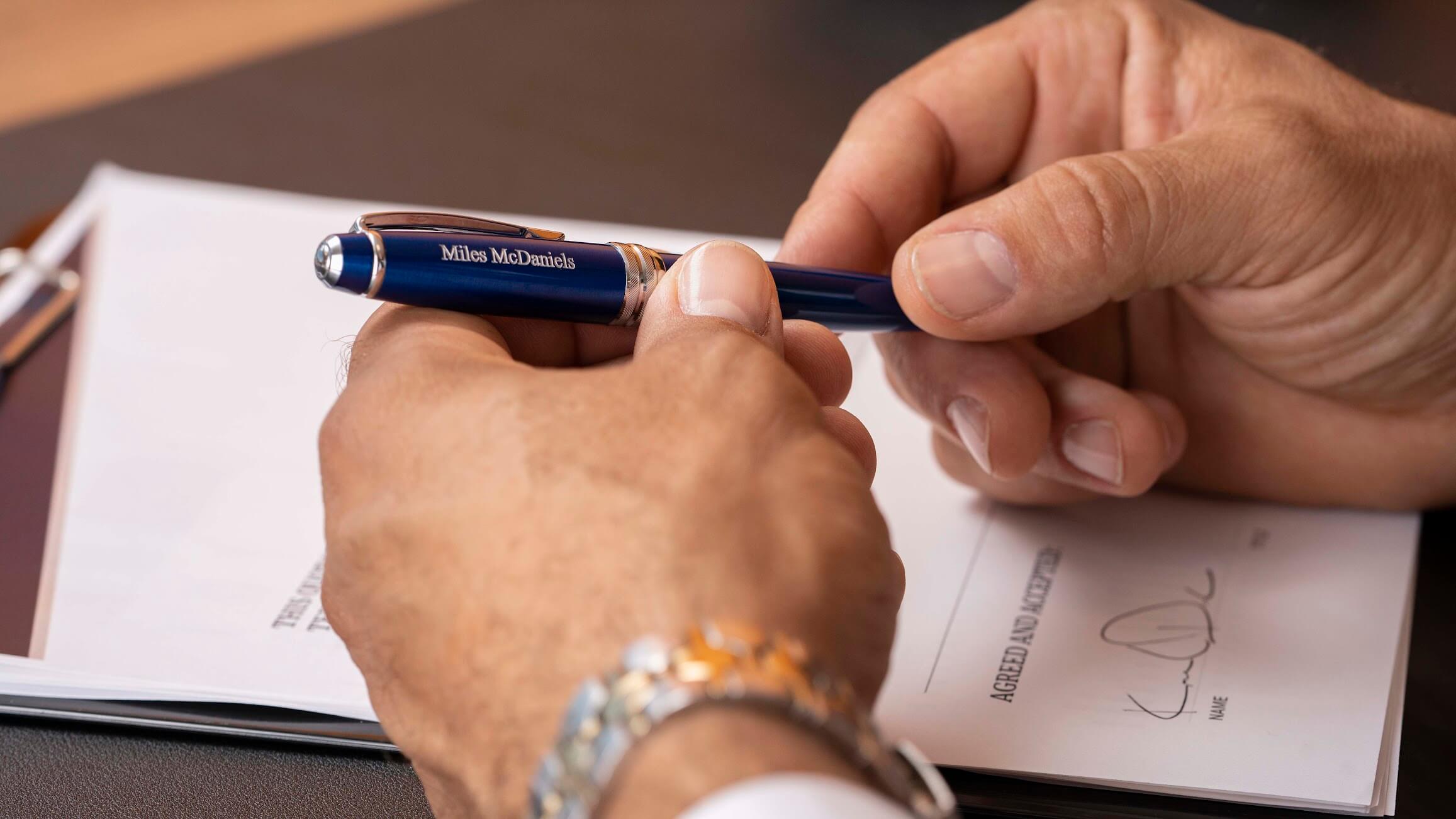 Man with watch holds a blue Cross Bailey custom engraved pen