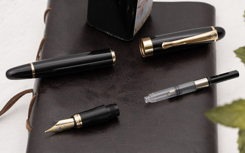 The Basic Parts of a fountain pen: the barrel, cap, nib, and a piston converter