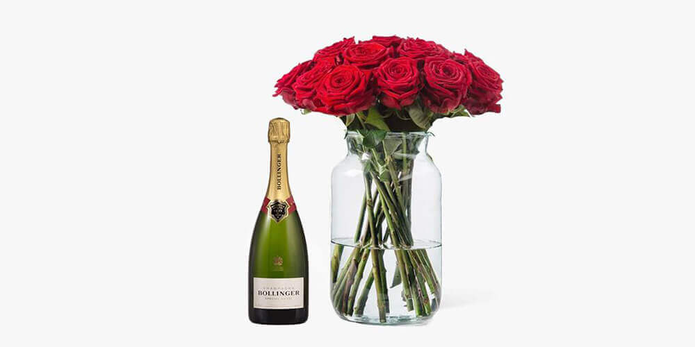 Bottle of champagne next to jar of long-stemmed red roses