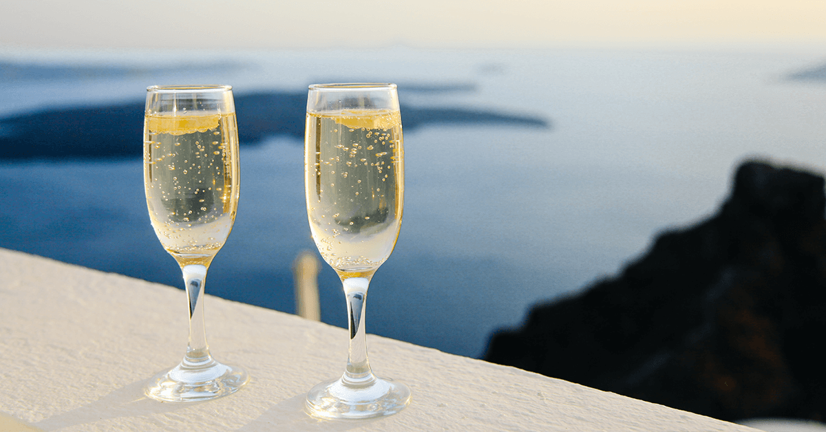 Two glasses of champagne with an ocean view in the background