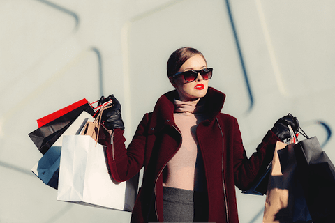 lady wearing sunglasses with shopping bags in both hands