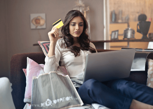 lady is holding a credit card to online shop