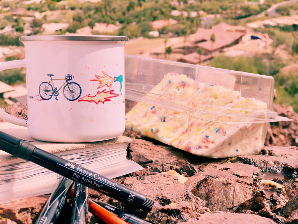 birthday cake and an enamel coffee mug with a bicycle design