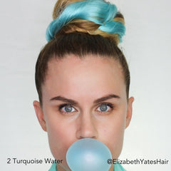 Long haired influencer Elizabeth Yates Hair blowing a blue bubble while wearing turquoise water blue Easy Updo Volume Extensions in a Big Topknot Bun
