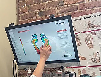 A salesperson goes over the scan results after the customer walked across the Aetrex foot scanner.