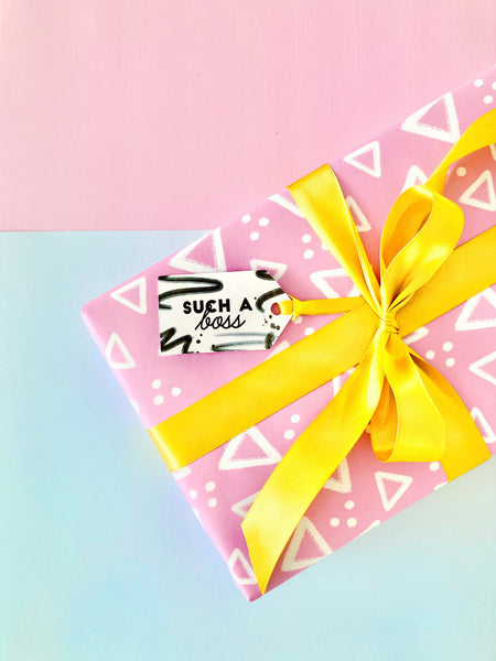 Pink geometric gift wrap by coconutacha, tied with gold ribbon and a black and white gift tag saying 'such a boss'