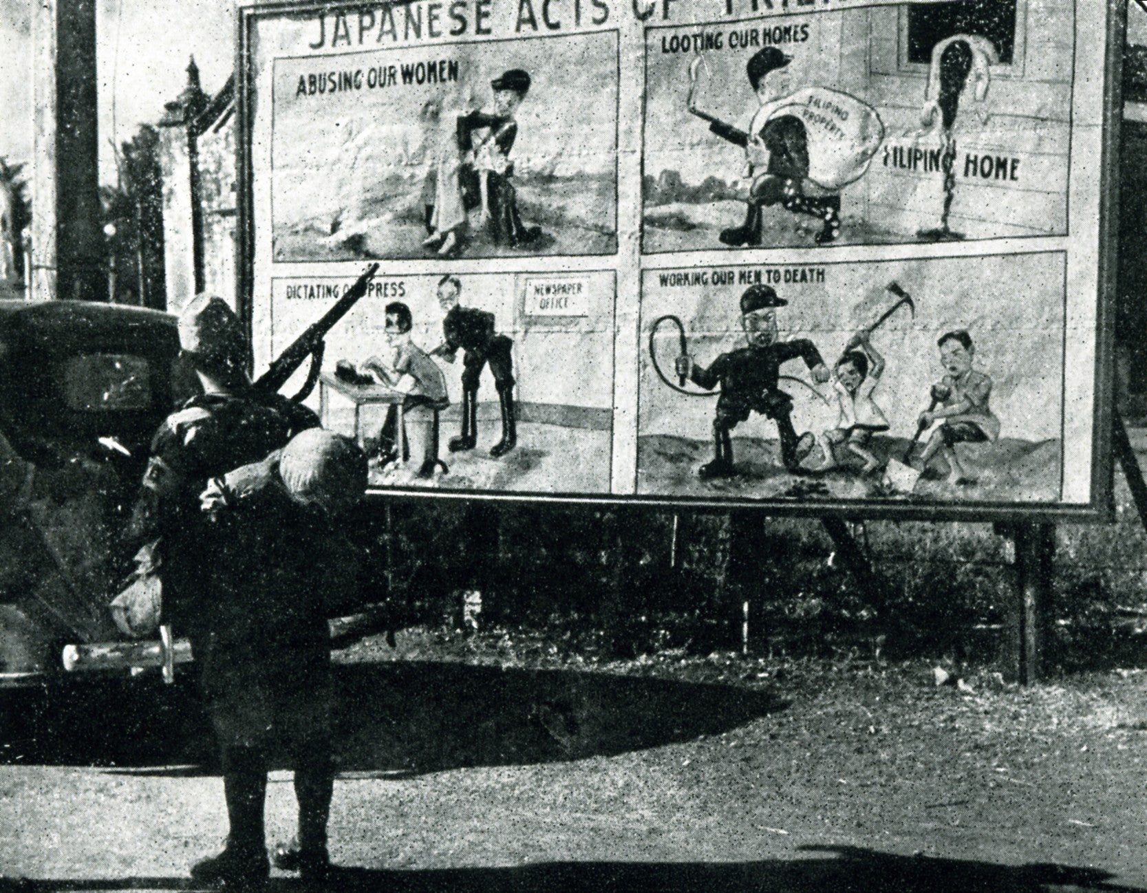 A Japanese soldier stands in front of US propaganda in the Philippines, 1943