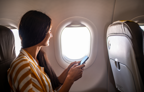 Women looking out window inside plane.