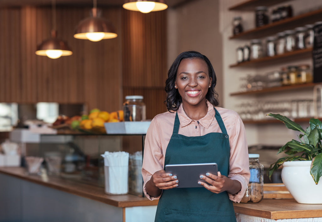 Smiling Woman at Counter with Tablet