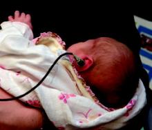 Photo of a baby wearing a small earpiece.