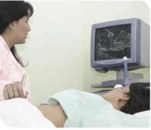Image 2 - shows a woman lying on a bed having an ultrasound scan