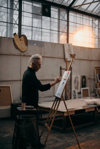 a painting master working in his workshop with paints