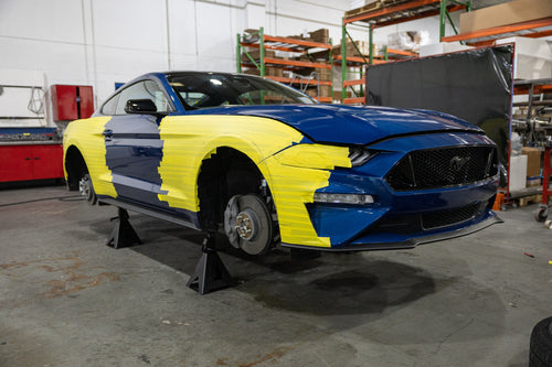 Mustang that is masked off and covered with blankets to protect it from the cutting and welding