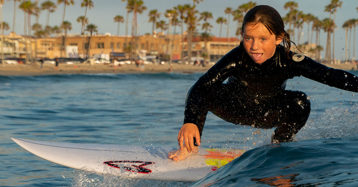 Little kid surfing in a Body Glove Phoenix Wetsuit