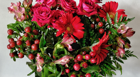 image of christmas flower bouquet of red roses and red berries on a white background