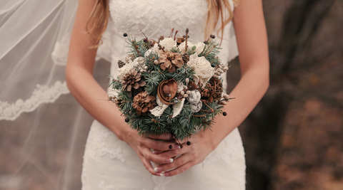 torso of bride holding bridal bouquet in front of her walking down the aisle