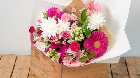 image of australian grown white and pink flower arrangement in a brown box on a wooden table and wrapped in white paper