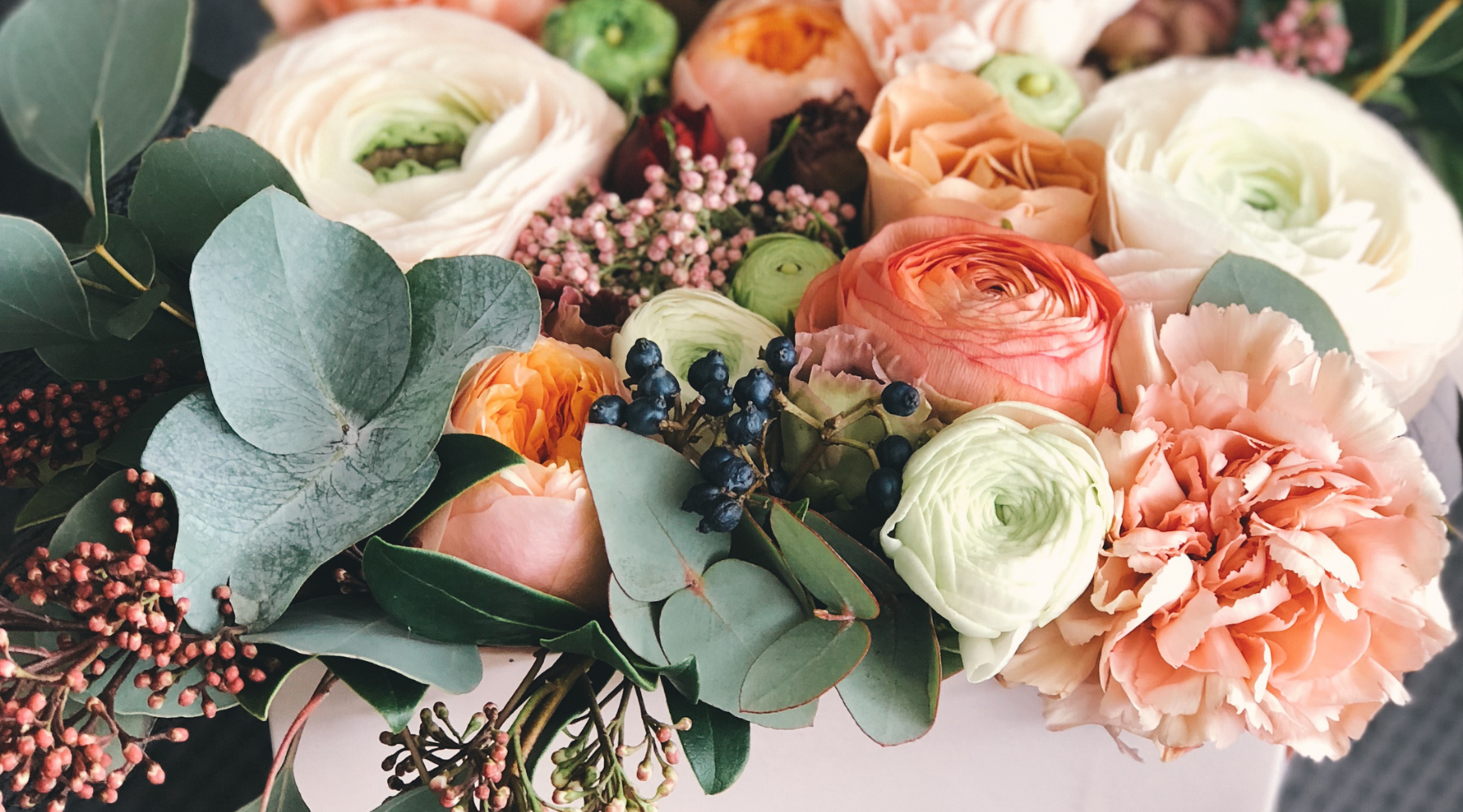 Image of bespoke white, pink and green sympathy flowers with red berries