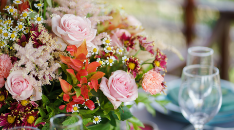 large christmas floral arrangement of pink, purple, yellow and white with red and green foliage