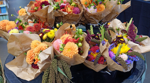 big, bold coloured bouquets wrapped in brown paper and organised in black tubs to be purchased and delivered