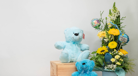 two blue stuffed bears and a beautiful yellow, white and blue flowers brisbane with greenery and with two welcome baby balloons