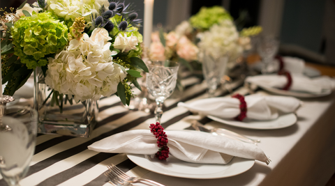 image of a table set for christmas with diy flower arrangements featuring large blooms and square vases for how to make christmas flower arrangements