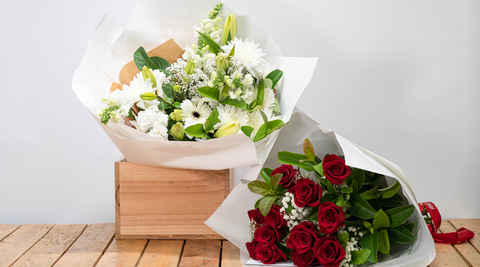 white arrangement and red roses local flowers arrangements on wooden table