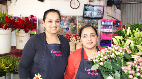 image of two female flower farm employees in their shop surrounded by blooms grown on their micro flower farm