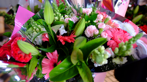 close up of beautiful mother's day bouquets with hot pinks and light pinks and lush greens ready for mother's day delivery